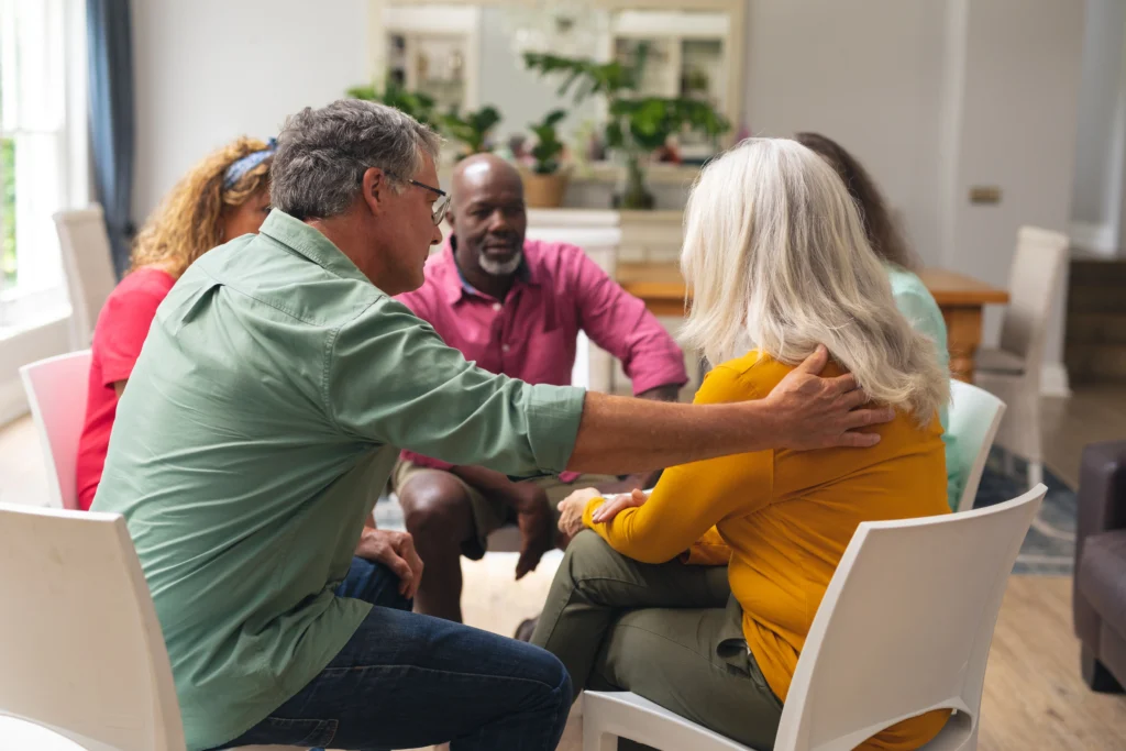 Senior_Man_Consoling_Crying_Female_During_Group_Therapy_Session_original_3140363